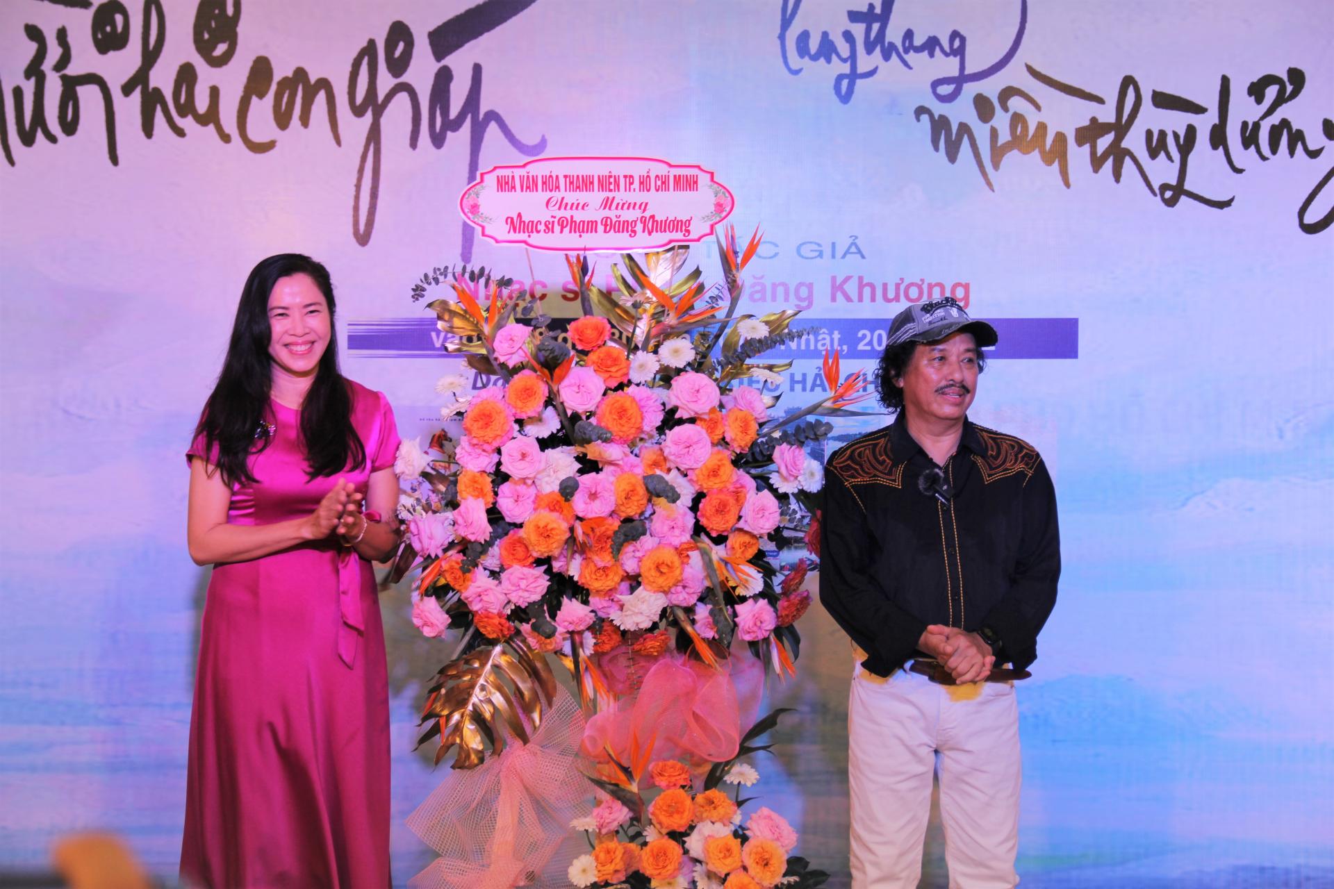 Phó Giám đốc NVH Thanh Niên - MC, ca sĩ Quỳnh Hoa tặng hoa chúc mừng NS Phạm Đăng Khương trong buổi ra mắt tập sách nhạc và sách ảnh. Ảnh: THÚY BÌNH